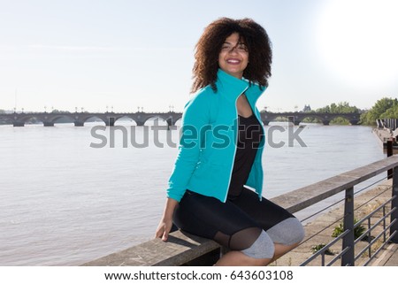 in font of bridge river cheerful girl in sport clothes outdoor