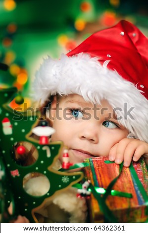Happy small girl in santa hat with present have a christmas