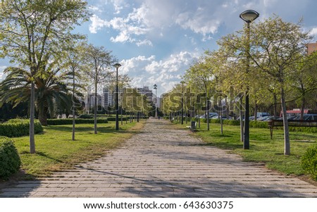 Gardens in the old dry riverbed of the Turia river in Valencia, Pedestrian walk way. Beautiful landscape leisure and sport area with trees, grass and trees, Spain