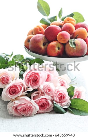 Plate of peaches with apricots and bouquet of roses
