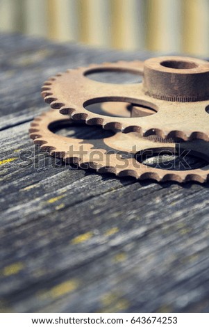 Filtered picture of cogwheels on a colorful wooden background