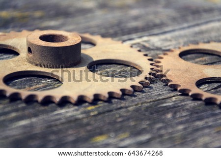 Filtered picture of cogwheels on a colorful wooden background