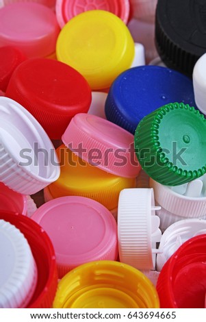 Collect plastic bottle caps. 
Close-up shot of stack of recyclable plastic bottle caps on white background. Bottle cap texture pattern as background.