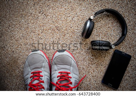 Sports set For Running shoes Smartphone and bluetooth headphones on rock wall background ready to fitness center 