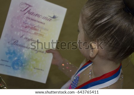 Beautiful girl in pink tracksuits with a gold medal around his neck , rhythmic gymnastics, mini-portrait, sports and health concept