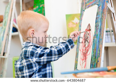 a child  paints at art lesson