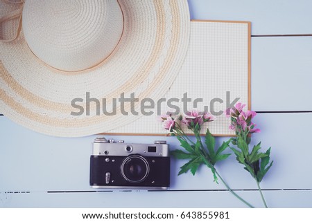 Flat lay open blank notebook, old camera on white wooden table
