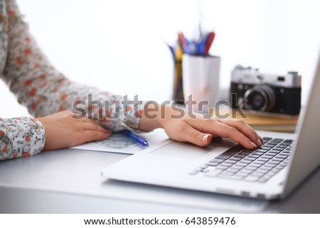 Portrait of young woman sitting at desk