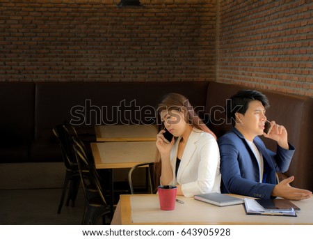 Picture of Asians business woman and businessman are talking on the phone in the coffee shop,Copy space in left side