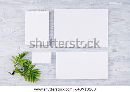 Corporate identity template, stationery with green foliage on soft light blue wooden board. Mock up for branding, graphic designers presentations and portfolios.
