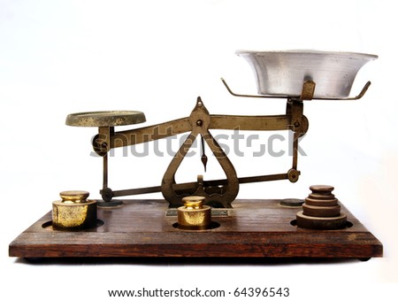 Antique bronze scale on a wooden base isolated on a white background