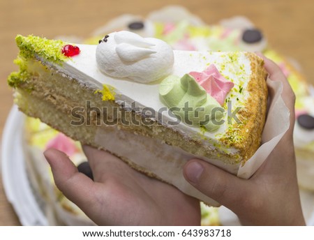 A child is holding a cake. Cropped image.
