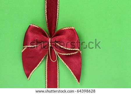 Gift in green wrapping with a red bow in close up