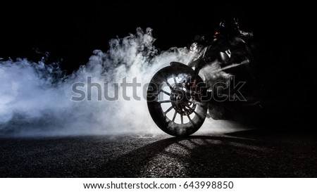 Detail of high power motorcycle chopper with man rider at night. Fog with backlights on background. Royalty-Free Stock Photo #643998850
