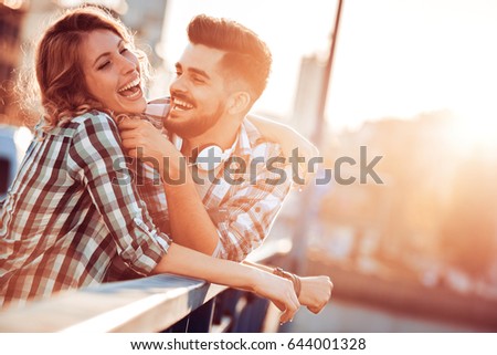 Happy young couple having fun outdoors and smiling.