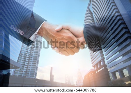 Double exposure of handshake in the city, building background, sun light , business partnership ,success concept,copy space.