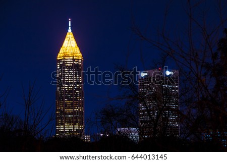 Night view of illuminated skyscrapers of Midtown Atlanta through branches, USA