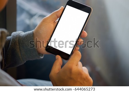 Man holding smart phone with blurred background.  For Graphic display montage.