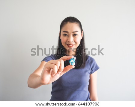 Asian woman showing miniature model house. Concept of buying house.