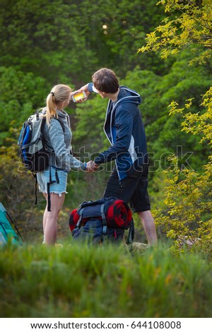 Young, smiling couple taking pictures with smartphone. Travel, vacation, holidays and adventure concept. Forest Mountain landscape background