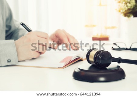 Wooden gavel, working lawyer in background. lawyer law justice judge gavel courtroom legal table concept