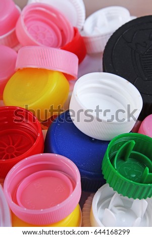 Collect plastic bottle caps. 
Close-up shot of stack of recyclable plastic bottle caps on white background. Bottle cap texture pattern as background.


