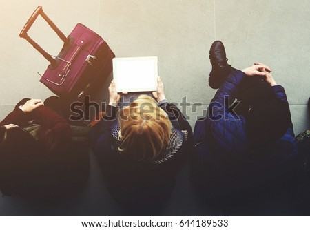 Top view of hipster girl is holding digital tablet with empty copy space screen for your advertising text message or content, while is sitting with friends in airport hall before start their journey
