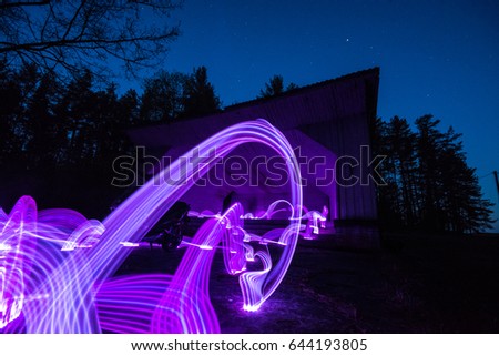 Long exposure image showing stars over the old scene in forest. Light painting in the night.
Abstract lights. Nature landscape at night. (Purple trails)