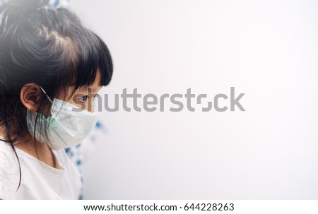Little asian girl wearing a protective mask in school Royalty-Free Stock Photo #644228263
