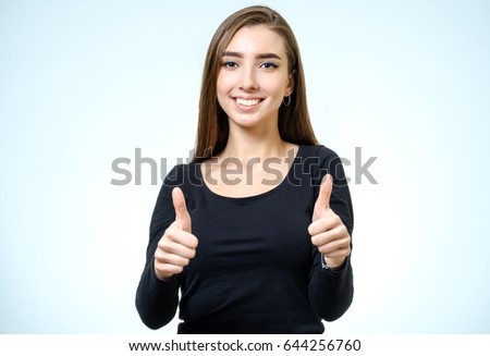 Smiling happy young brunette woman showing thumbs up gesture isolated on white background