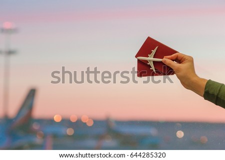 Closeup an airplane model toy and passports at the airport background big window at dawn