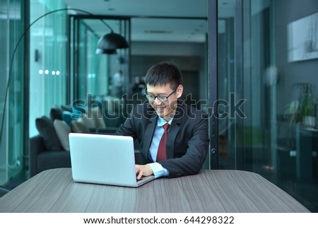 Asian Businessman using laptop in a conference room