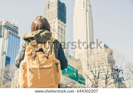 Image of a young traveller just arrived in New York city holding her backpack