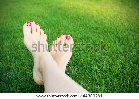 Woman foots on a green grass