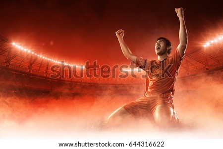 soccer player on soccer stadium celebrating a goal on red smoke background Royalty-Free Stock Photo #644316622
