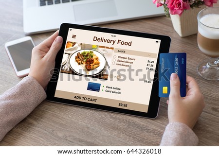 woman hands holding credit card and tablet computer with app delivery food on screen Royalty-Free Stock Photo #644326018
