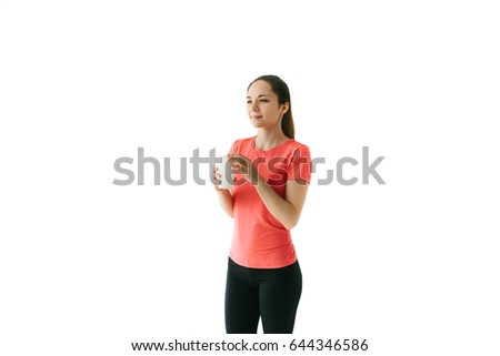 Pretty young girl drinks after sports training and smiles. On a white background