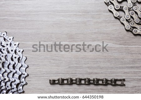 White metal rusty and oily assorted items, bicycle parts like chain and cassette related with bicycle repair on a wooden background with copyspace