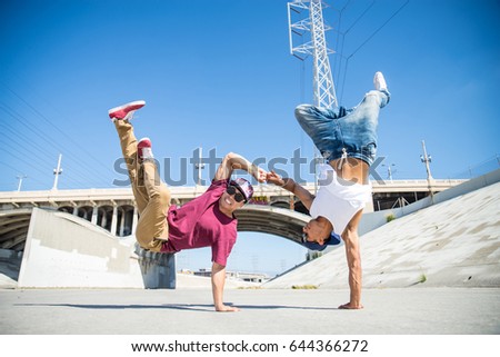 Two bboys doing some stunts - Street artist breakdancing outdoors Royalty-Free Stock Photo #644366272
