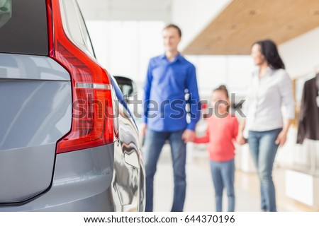 Selective focus on a car man woman and their daughter choosing a new auto on the background copyspace family buying a new car at the dealership love travelling rental offer sales discount ownership Royalty-Free Stock Photo #644370196