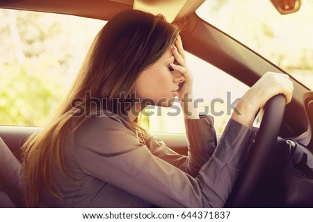 Stressed woman driver sitting inside her car  Royalty-Free Stock Photo #644371837