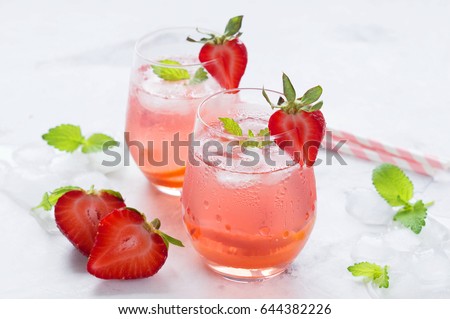 Iced tea with strawberries and mint. On a white background.