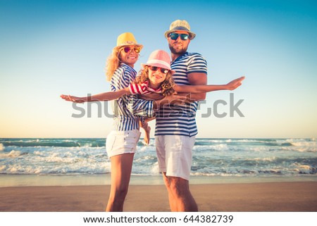 Happy family on the beach. People having fun on summer vacation. Father, mother and child against blue sea and sky background. Holiday travel concept