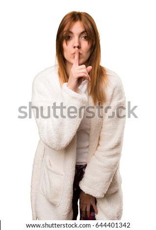 Young woman in dressing gown making silence gesture