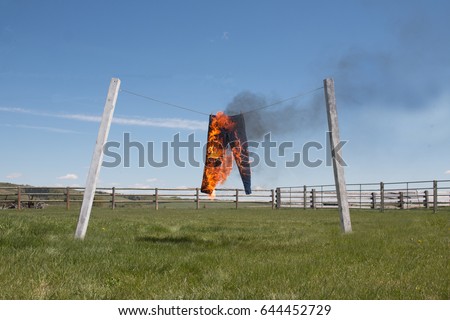 Liar Liar
This is a photo of a pair of pants hanging on an outdoor laundry line that have been set on fire. It is a conceptual representation of the children's rhyme "Liar Liar pants on fire." 
