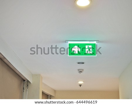 Green illuminated emergency exit sign in hotel.
