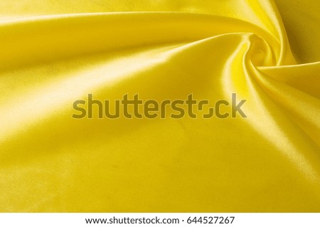 Texture background pattern. Silk fabric, yellow fabric. On a black background. Flower textile or fabric. Texture of fabric textiles, material, woven.