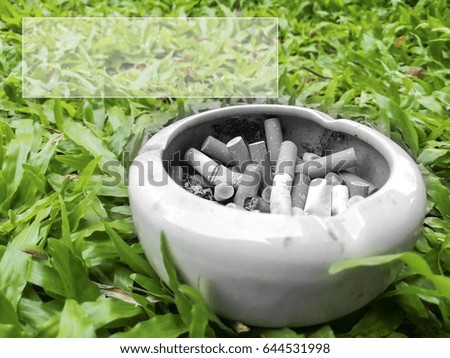 Closeup cigarette butts in ashtray, concept of world no tobacco day ,selective focus as cigarette,on the grass