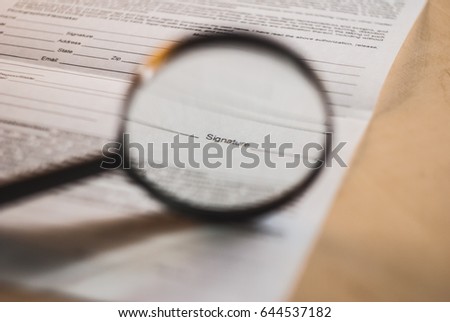 Sign here, under a magnifying glass,