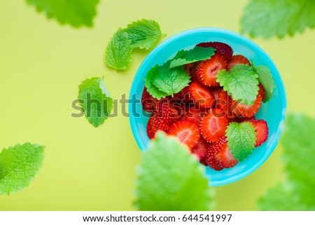 Bowl with fresh strawberries  and mint leaves, top view